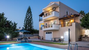 Un bâtiment à deux étages doté d’une piscine, d’un espace extérieur aménagé et d’un balcon bien éclairé.