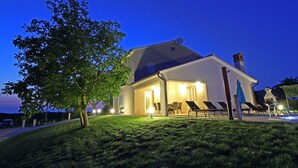 A two-story house with a covered patio and a swimming pool.