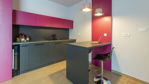 A modern kitchen with grey cabinets, a central island, and pendant lighting.