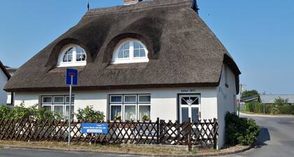 Nostalgie dans une maison de vacances romantique avec un toit de chaume et une cheminée devant l'île d'Usedom