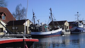 Een jachthaven met meerdere boten afgemeerd, waaronder een vissersschip genaamd 'Jennifer'.