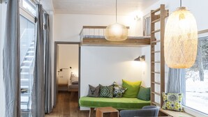 A cozy room with a bunk bed, a wooden table, and a hanging light fixture. - Zugspitz-Rauschen 1 - Live like a dream right on the riverbank with a view of the Zugspitze (Garmisch-Partenkirchen)