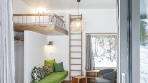 A modern interior with a loft bed, a green sofa, a ladder, and a desk area. - Zugspitz-Rauschen 1 - Live like a dream right on the riverbank with a view of the Zugspitze (Garmisch-Partenkirchen)