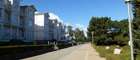 Una calle bordeada de edificios históricos, una acera y farolas.