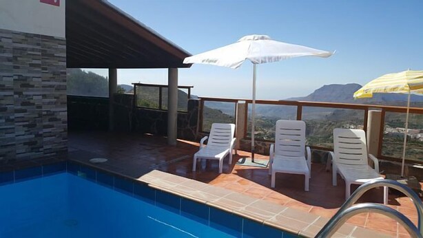 An outdoor pool area with a clear view of the landscape, including mountains and a town. - Rural House of Perera with private pool for 4 people (San Bartolomé de Tirajana)