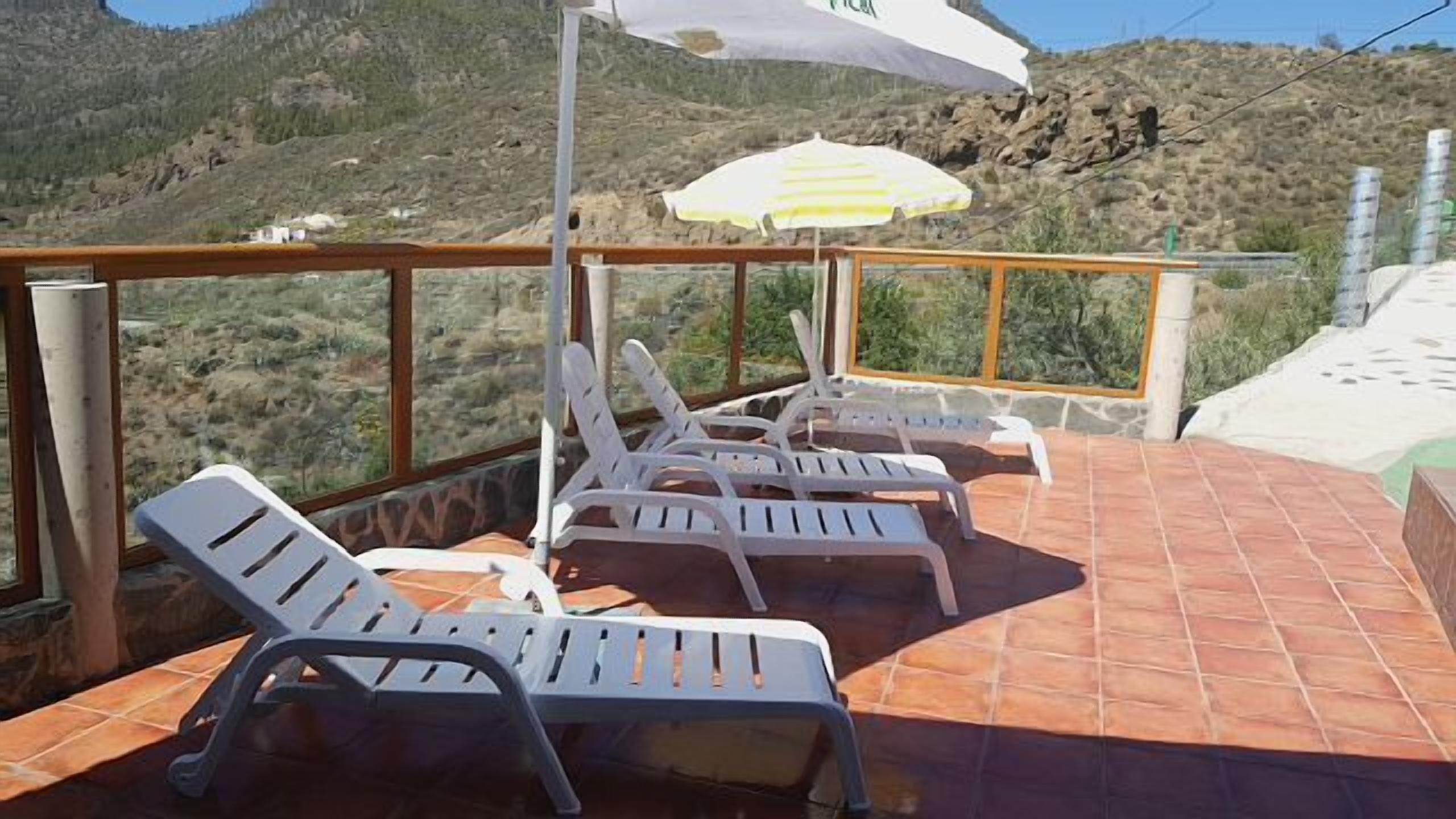 A terrace with outdoor seating and a mountain view.