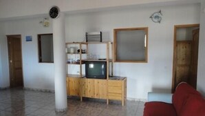 A living room with a wooden cabinet, a television, and a red sofa. - Rural House of Perera with private pool for 4 people (San Bartolomé de Tirajana)