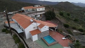A property with a swimming pool, a patio area, and a view of the surrounding hills. - Rural House of Perera with private pool for 4 people (San Bartolomé de Tirajana)