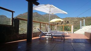 A terrace with two sun loungers and a white umbrella, overlooking a mountainous landscape. - Rural House of Perera with private pool for 4 people (San Bartolomé de Tirajana)