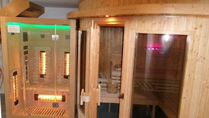 A sauna with wooden walls and a glass door, a bench, and a small table with a bowl. - Newly built comfortable apartment with wellness area  (Jachenau)