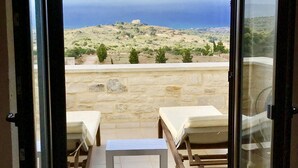 Ein Zimmer mit Blick auf eine Küstenlandschaft durch eine Glastür.