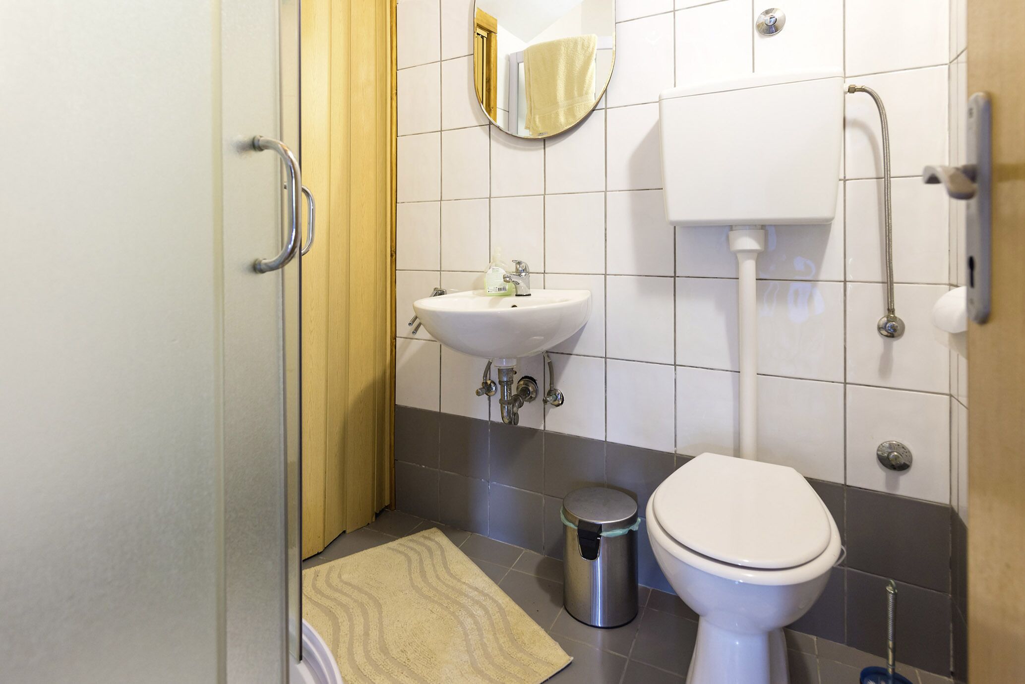 Et badeværelse med toilet, håndvask og spejl.