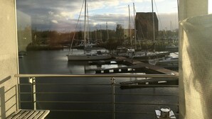 A marina with several boats docked, a view of the water, and a cloudy sky. - Maritime boutique vacation apartment AM YACHTHAFEN (Greifswald)