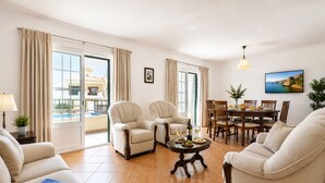 A spacious living room with a dining area, large windows, and a pool view. - 8 bedroom Villa Bella, Private Pool, Albufeira  Close to Strip & Old Town (Albufeira)