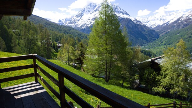 A wooden deck with a view of a mountain range and a valley. - Magic chalet for 2 people (Villaz/la Sage - Evolène)