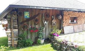 Un bâtiment rustique en bois, doté d’un toit en pente, d’une porte en bois et d’une petite fenêtre.