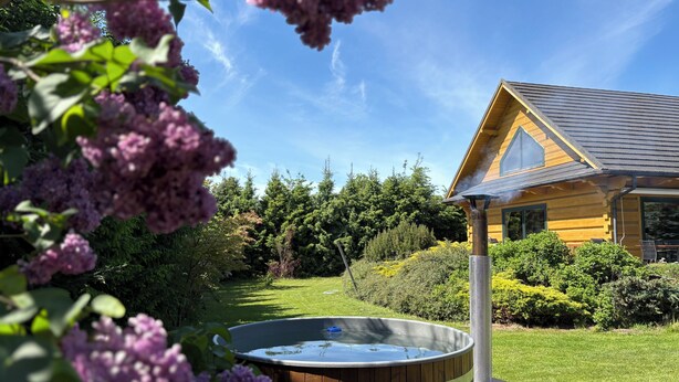A wooden cabin with a hot tub in a lush garden. - Luxury wooden house with garden on the Baltic Sea with sauna / whirlpool near Swinoujscie (Kolczewo)