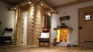 Een gezellige kamer met een stenen muur, een open haard en een houten plafond.