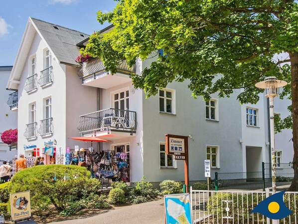 A two-story building with a balcony and a sign indicating it is a guesthouse. - Vacation apartment Strandläufer - Whg. 06 // - Strandläufer 06 (Heringsdorf)