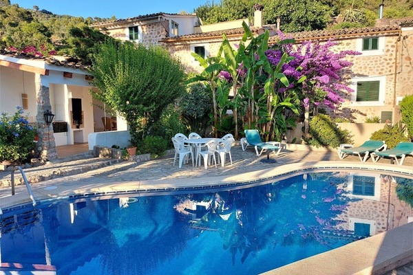 Blick auf Pool, überdachte Terrasse und Haus