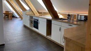 Une cuisine moderne dotée de fenêtres de toit, d’un four encastré et d’un grille-pain.