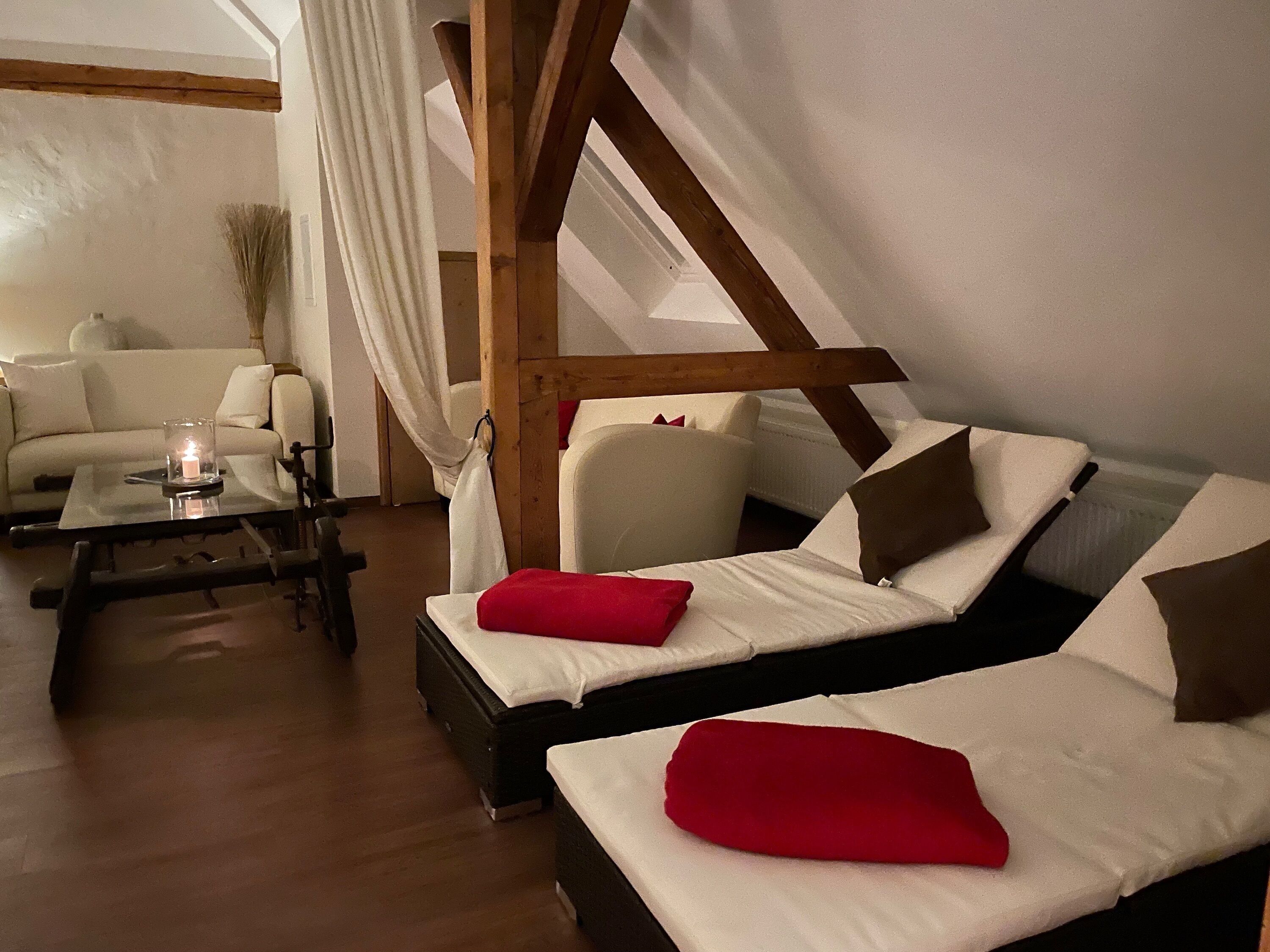 Une pièce confortable avec deux lits, un canapé, une table avec une bougie et une vue sur l’extérieur.