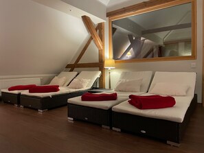 A room with two reclining beds, a wooden ceiling beam, a large mirror, and a lamp. - Exclusive ***** 6 apartments for 12-27 persons To Bergwiese (Fürstenau)