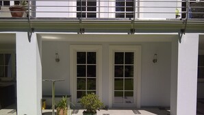 A house with a covered porch, two doors, and potted plants. - Modern apartment in spacious villa, 3,000 sqm property, south-facing slope, forest, WIFI (Michendorf OT Wilhelmshorst)