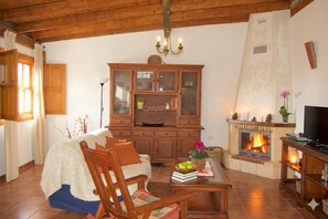 A cozy living room with a fireplace, wooden furniture, and a television. - Casa Samuel, rural escape with pool, Las Vegas village (Granadilla de Abona)