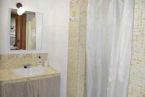 Ein Badezimmer mit Waschbecken, Spiegel und Duschvorhang.