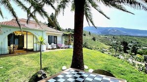 A house with a patio, a view of the countryside, and a mountain in the background. - Großzüg. House with panoramic views of sea, mountains & valley + optional apartment (Tajuya)