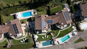Un quartier résidentiel composé de plusieurs maisons, chacune dotée d’une piscine et de panneaux solaires sur le toit.