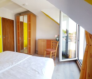 Une chambre à coucher avec un lit, un bureau, une chaise et une armoire.