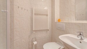Een badkamer met toilet, wastafel en handdoekrek.