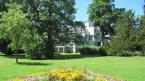 A well-maintained garden with a variety of colorful flowers and trees in front of a modern building. - Enjoy holidays in a prime location in Konstanz, the holiday in the south right on the shore (Konstanz)