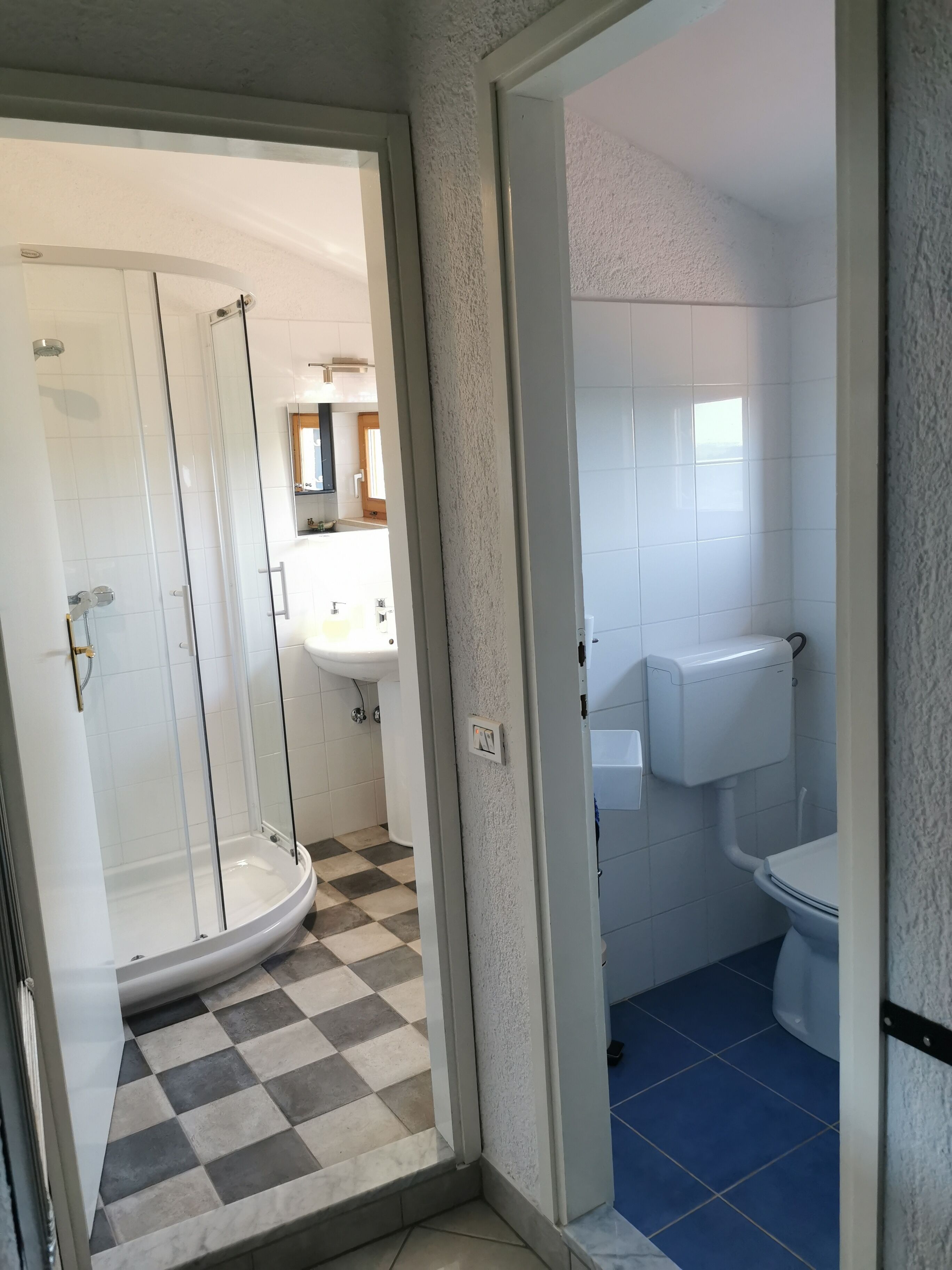 A bathroom with a shower, toilet, and sink.