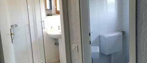 A bathroom with a shower, toilet, and sink.