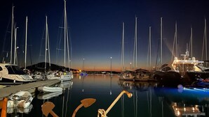 Eine Marina im Abenddämmerung mit mehreren angestückten Segelbooten.