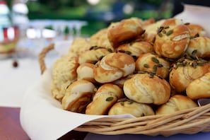 A basket of freshly baked bread rolls with seeds on a table.