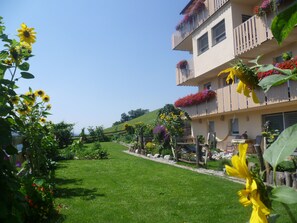 Stunning garden area with lush greenery and vibrant flower boxes adorns the hotel's modern exterior.