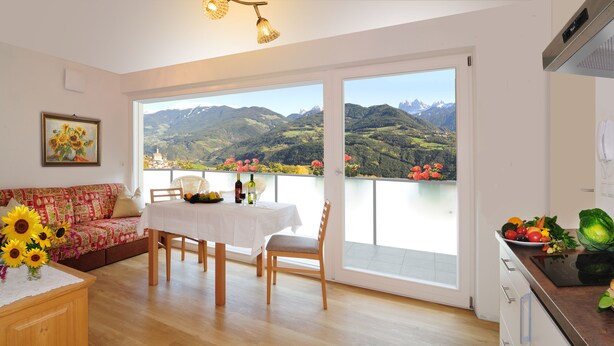 Una habitación con balcón, comedor y cocina.