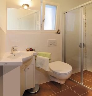 A bathroom with a sink, mirror, toilet, and a glass shower enclosure. - New, comfortable apartment near the village, right on Kastanienweg (Feldthurns)