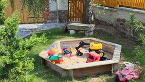 A sandbox with toy vehicles and a pink toy car. - Apartment "Bauernstube" with pool and sauna use on a restored 3 side courtyard (Meißen)