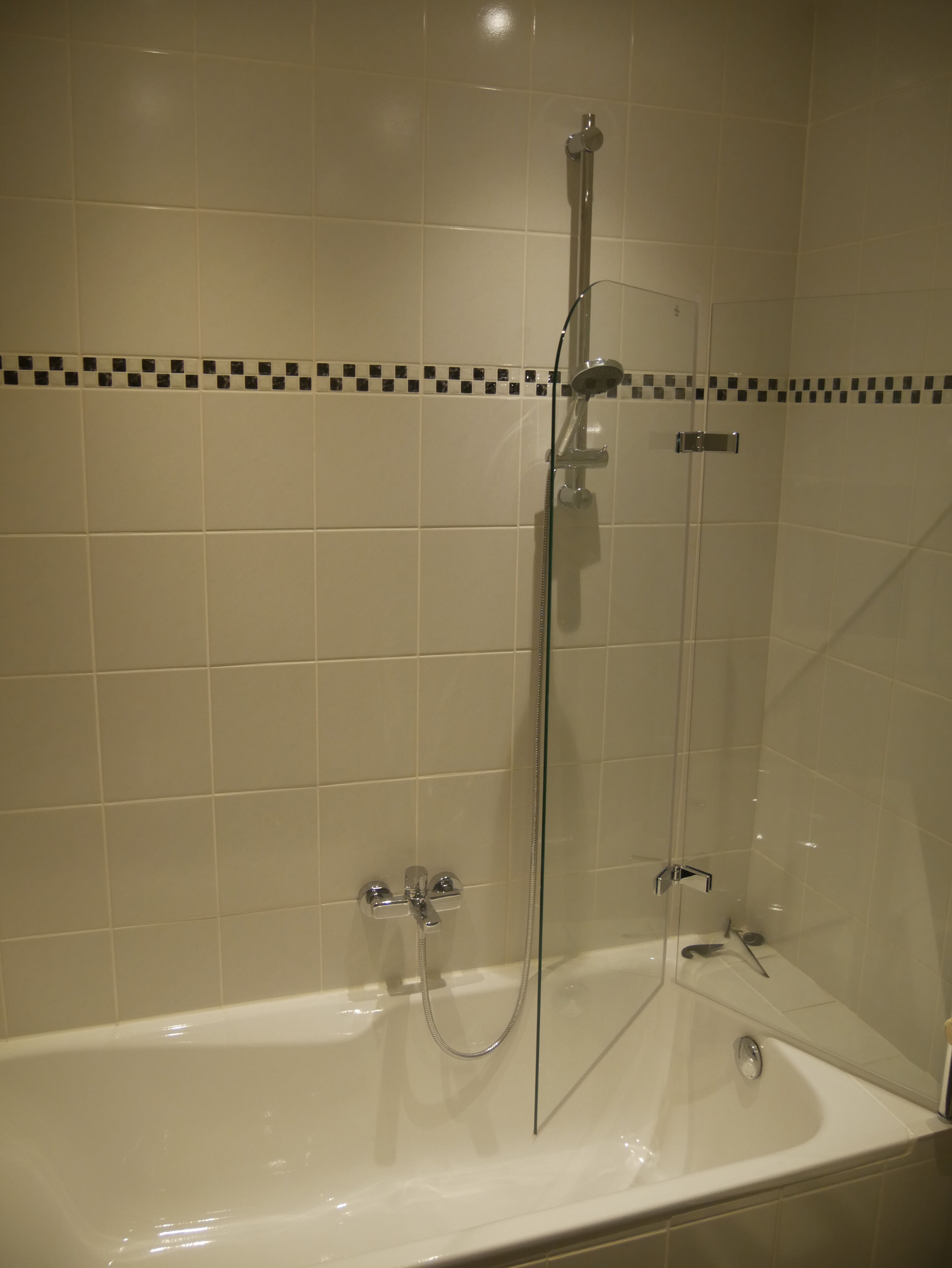A bathroom with a bathtub and a glass-enclosed shower.