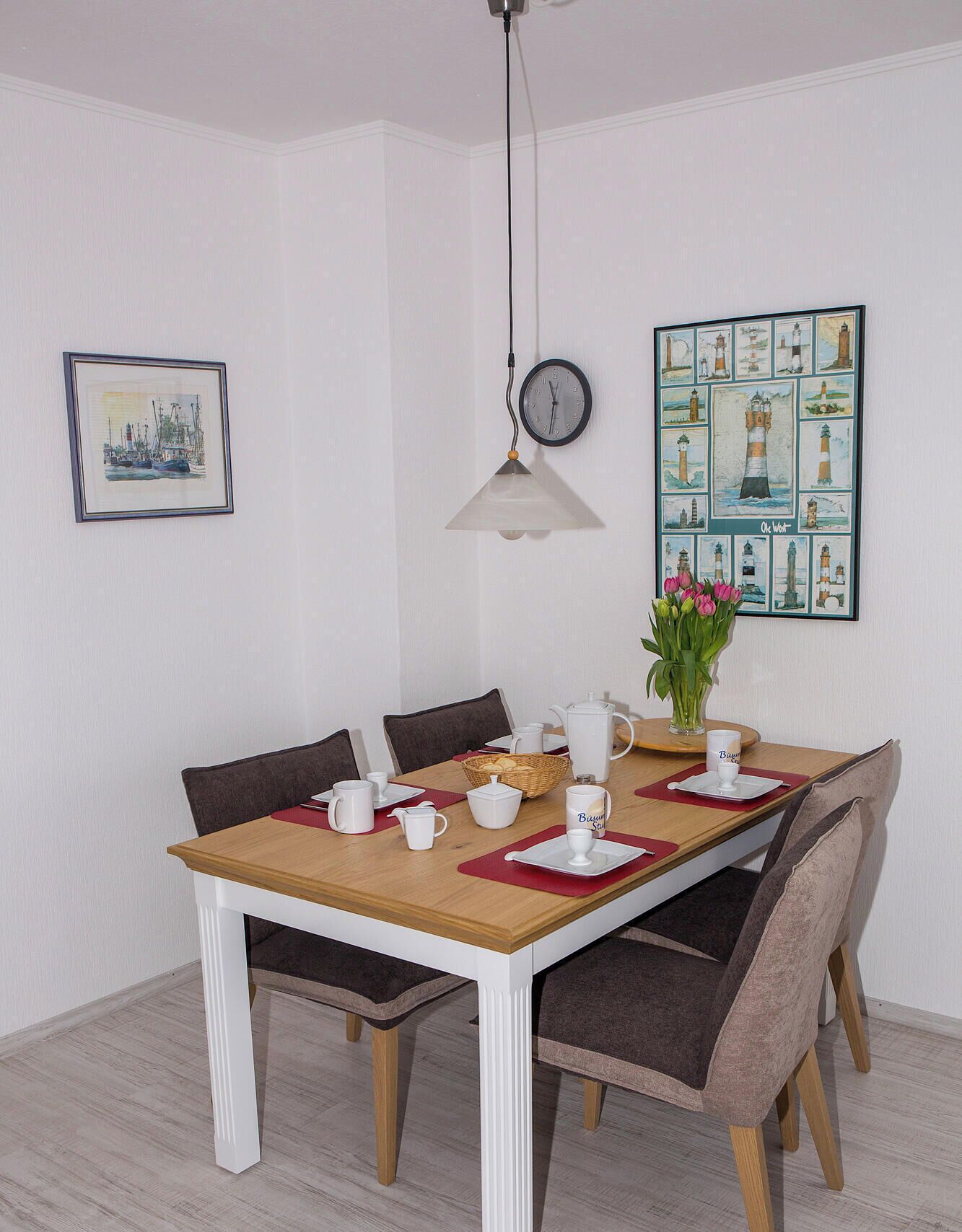 A dining area with a wooden table, chairs, and a clock on the wall.