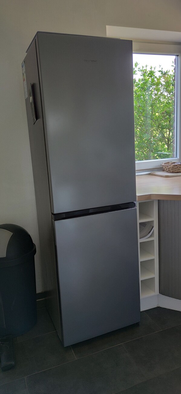 A stainless steel refrigerator in a kitchen with a window view. - Fantastic holiday home on the left Lower Rhine between the Rhine and Wisseler See (Kalkar)
