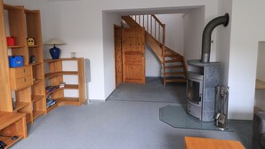 A room with a wooden staircase, a fireplace, and built-in wooden shelving.
