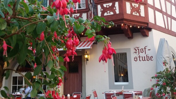 A traditional half-timbered building with a sign reading "Hofstube".