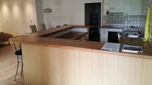 A modern kitchen with a wooden island, white cabinets, and a built-in oven.