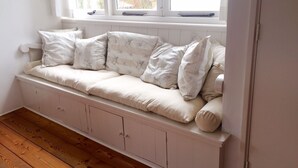 A white wooden bench with cushioned seating and storage cabinets underneath. - House for 5 persons, old farmhouse with luxe bathroom, 3 sleeping rooms (Groet)